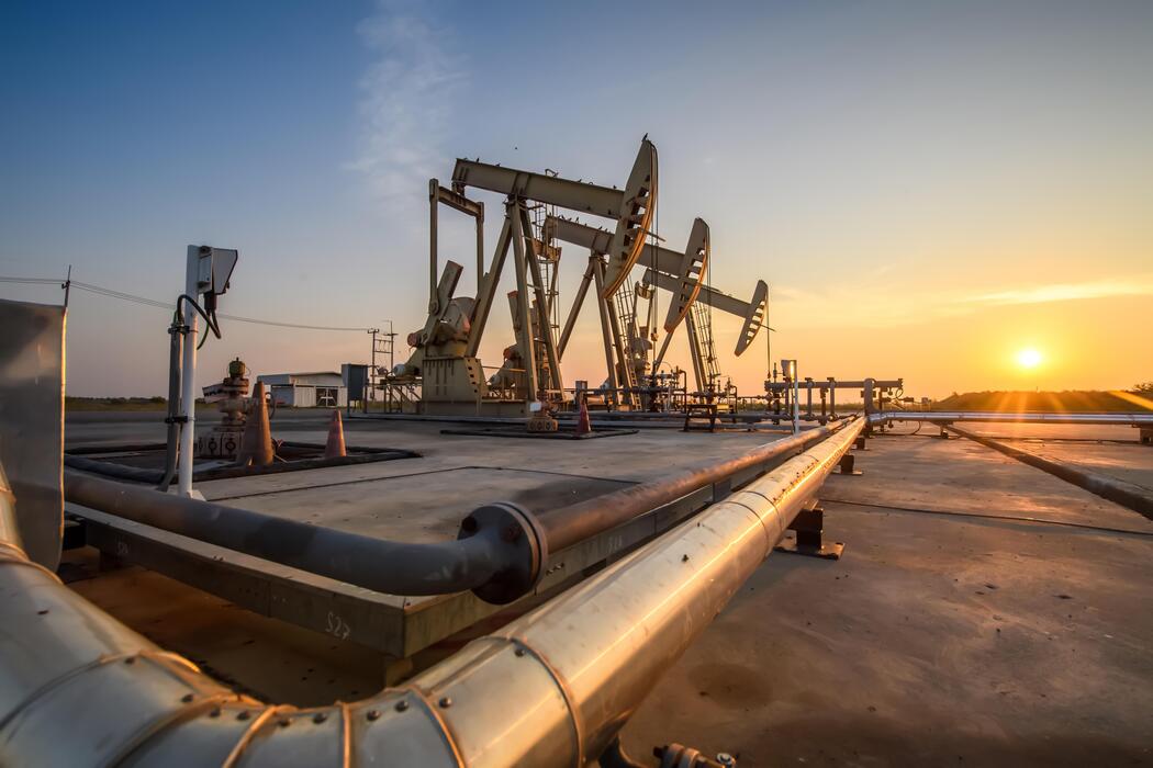 Upstream pumpjacks and piping at golden sunset