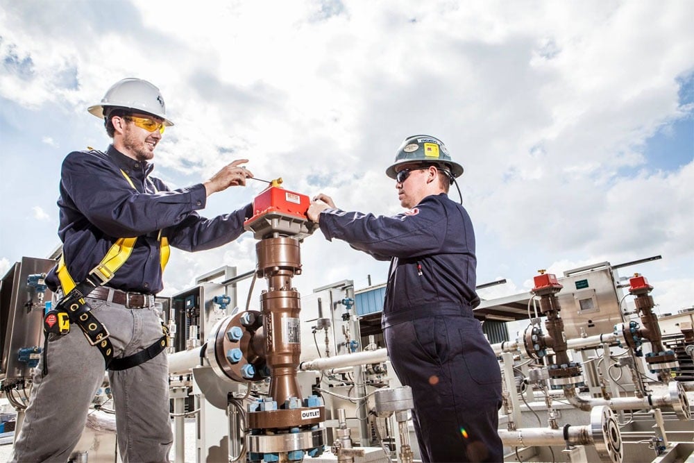 Field operators working on wellhead equipment